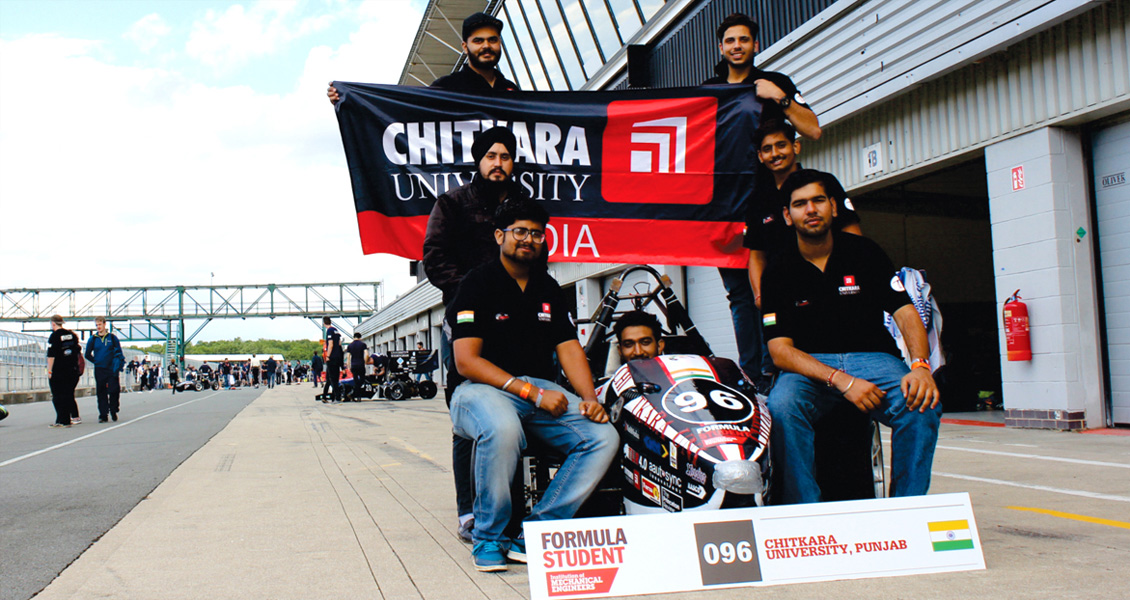 The image shows students in a black T-shirt with a chitkara university flag.
