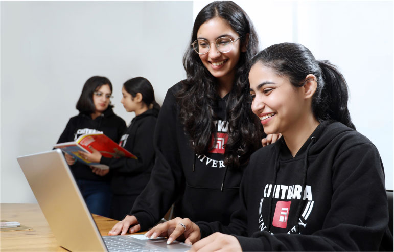 The illustration shows the students of chitkara university in black sweatshirts. Two are working on their laptop, and another two are holding the book.