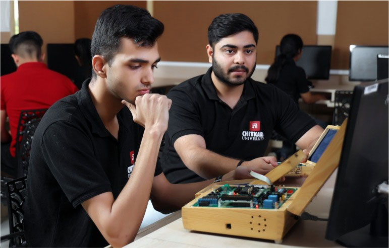 The image shows the two students of electrical engineering from chitkara university working on their projects.