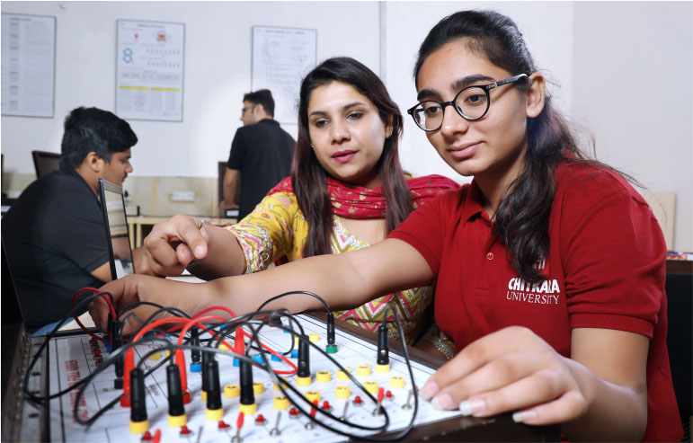 The image shows the student and teacher of electrical engineering from chitkara university working on their project.