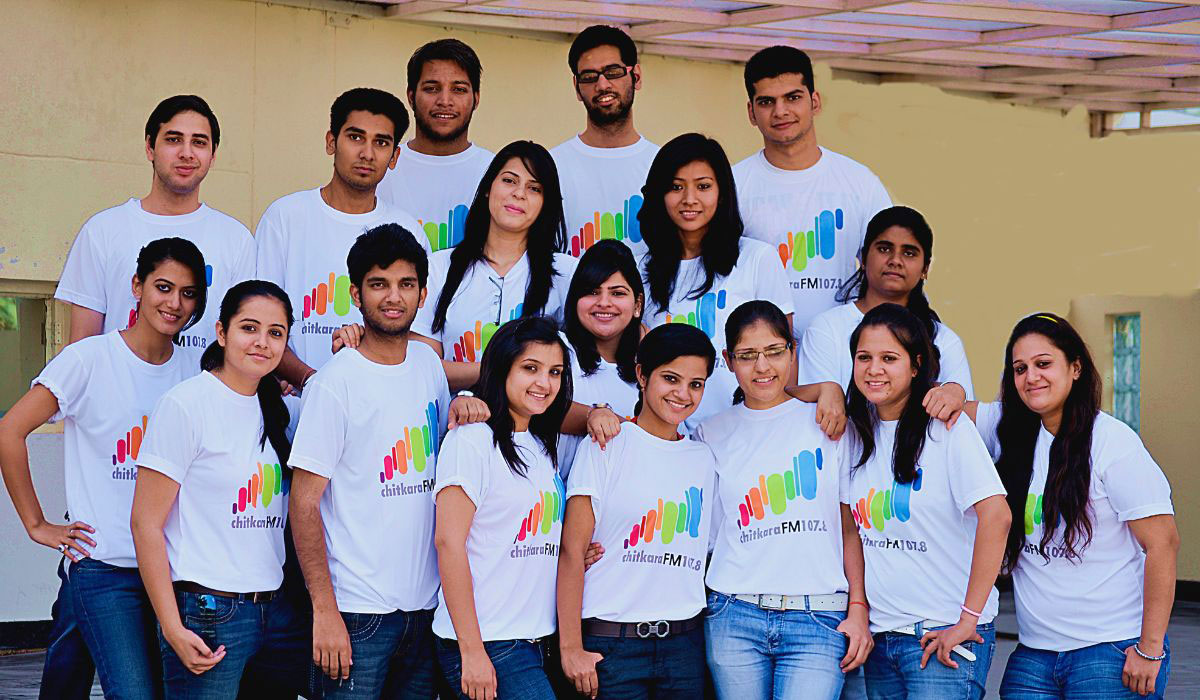 A group of students standing together for a group picture, representing the diverse and collaborative nature of a Mass Communication Course.