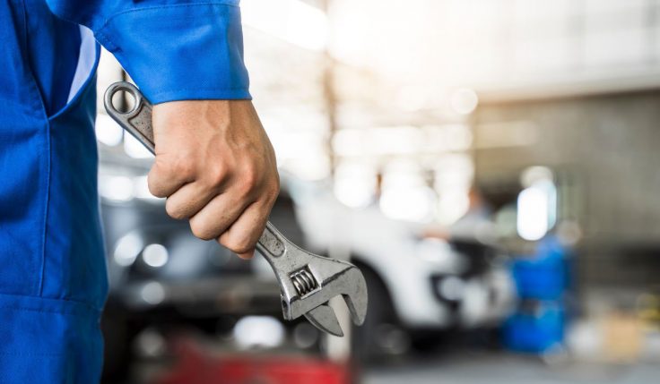 A person holding an adjustable wrench, representing hands-on work in the Frontiers of Mechanical Engineering.