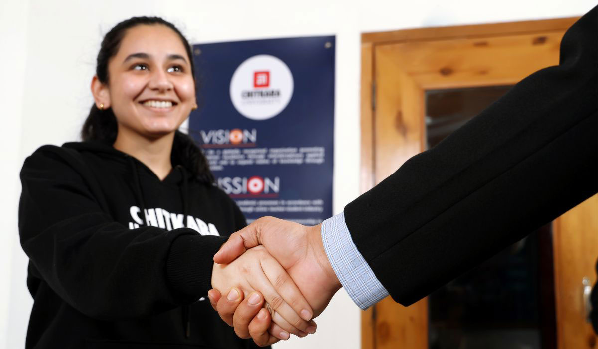 A student shaking hands with a professional, symbolizing networking and relationship-building during an MBA program.