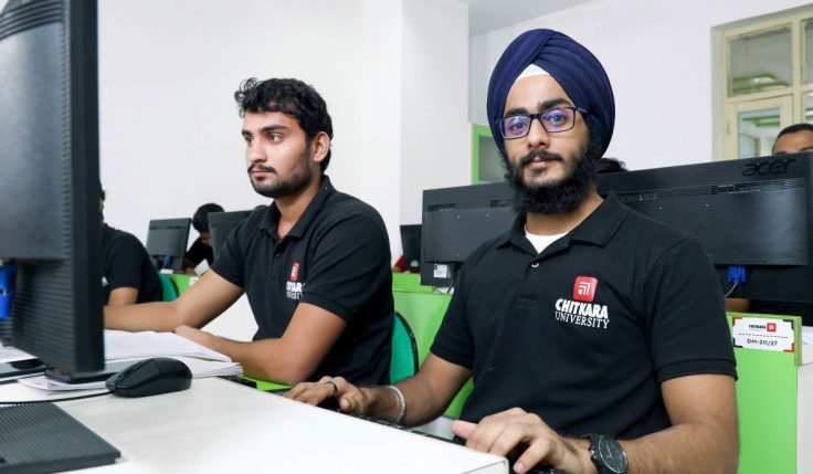 Two students working on a computer, representing how a BCA degree can lead to various opportunities in the IT industry.